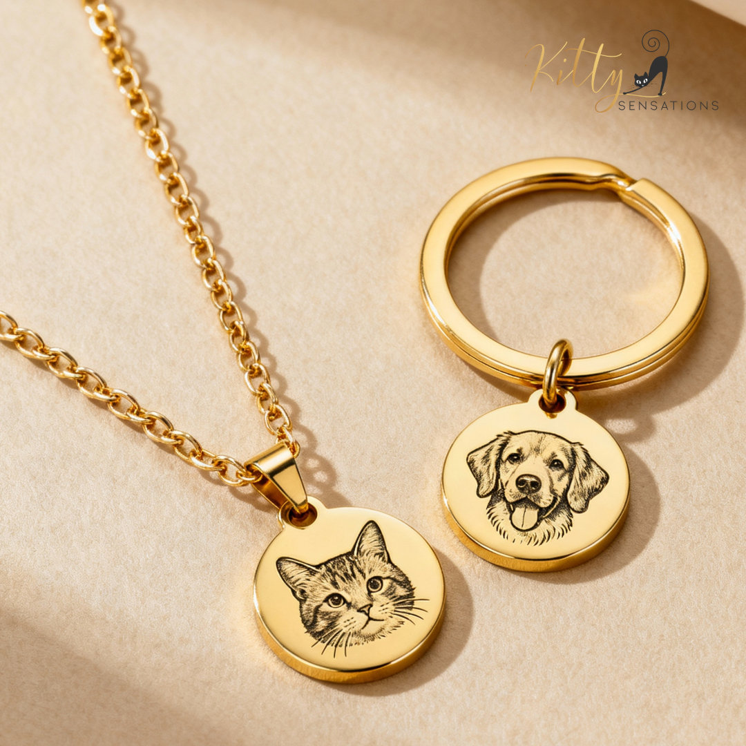 Gold necklace and keychain with engraved cat and dog faces on a beige background.
