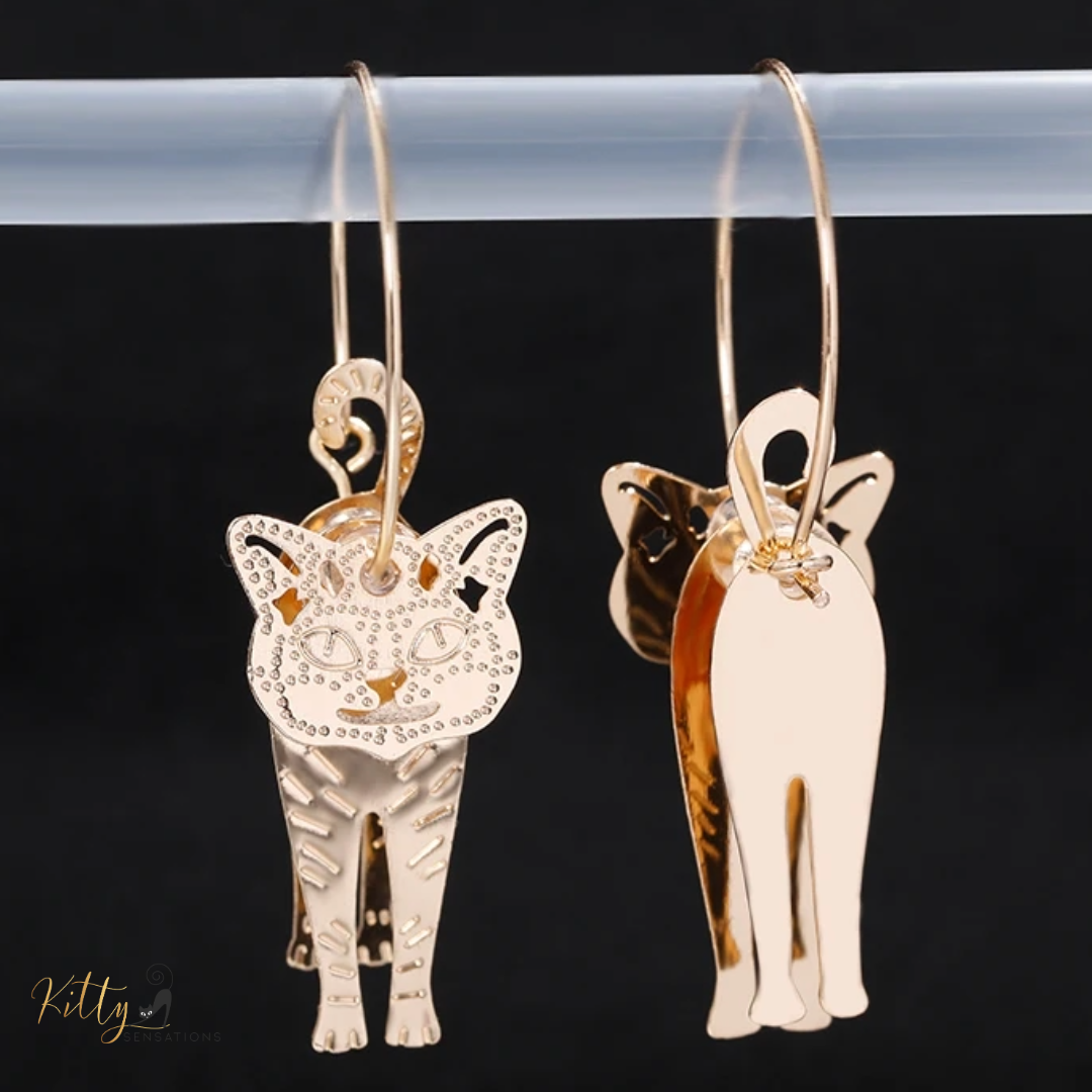 Moving Cat Hoop Earrings - Bronze-Gold Color: These absolutely gorgeous and dynamic earrings are a must have for a cat loving lady. The subtle bronze-gold colored earrings show pierced profiles of a cute kitty in three different bronze-gold colored foils that move as you move, depicting the graceful movements of your lovely cat. https://www.kittysensations.com/products/moving-cat-hoop-earrings