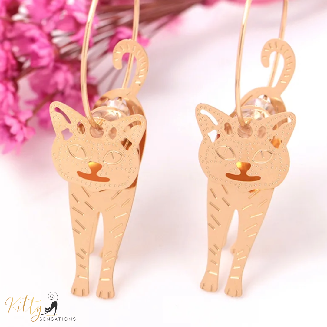 Moving Cat Hoop Earrings - Bronze-Gold Color: These absolutely gorgeous and dynamic earrings are a must have for a cat loving lady. The subtle bronze-gold colored earrings show pierced profiles of a cute kitty in three different bronze-gold colored foils that move as you move, depicting the graceful movements of your lovely cat. https://www.kittysensations.com/products/moving-cat-hoop-earrings