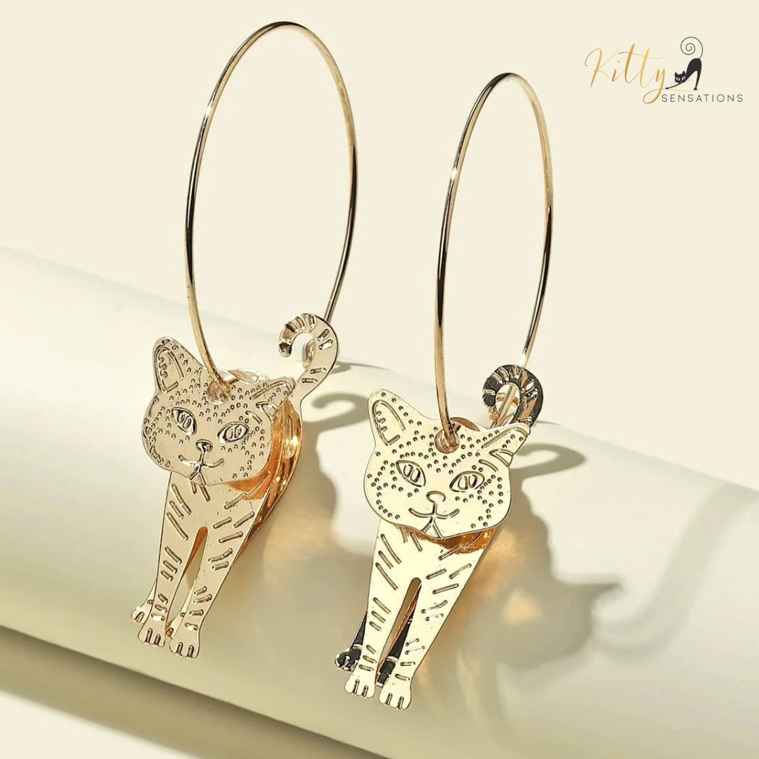 Moving Cat Hoop Earrings - Bronze-Gold Color: These absolutely gorgeous and dynamic earrings are a must have for a cat loving lady. The subtle bronze-gold colored earrings show pierced profiles of a cute kitty in three different bronze-gold colored foils that move as you move, depicting the graceful movements of your lovely cat. https://www.kittysensations.com/products/moving-cat-hoop-earrings