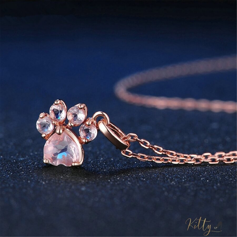 cat paw necklace in rose gold on blue surface 13405465-pink