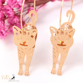 Moving Cat Hoop Earrings - Bronze-Gold Color: These absolutely gorgeous and dynamic earrings are a must have for a cat loving lady. The subtle bronze-gold colored earrings show pierced profiles of a cute kitty in three different bronze-gold colored foils that move as you move, depicting the graceful movements of your lovely cat.  https://www.kittysensations.com/products/moving-cat-hoop-earrings