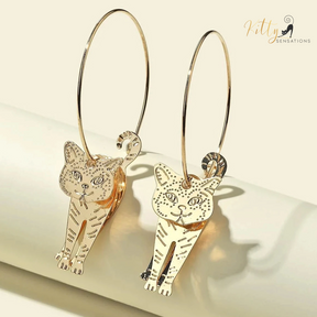 Moving Cat Hoop Earrings - Bronze-Gold Color: These absolutely gorgeous and dynamic earrings are a must have for a cat loving lady. The subtle bronze-gold colored earrings show pierced profiles of a cute kitty in three different bronze-gold colored foils that move as you move, depicting the graceful movements of your lovely cat.  https://www.kittysensations.com/products/moving-cat-hoop-earrings