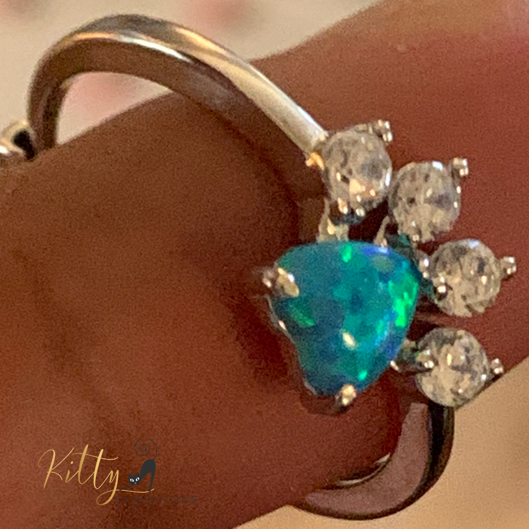 Solid 925 sterling silver cat paw ring with a central heart-shaped blue fire opal stone and four smaller AAA quality clear Cubic Zirconia stones for kitty toes - Rhodium-plated for anti-tarnish and durability.