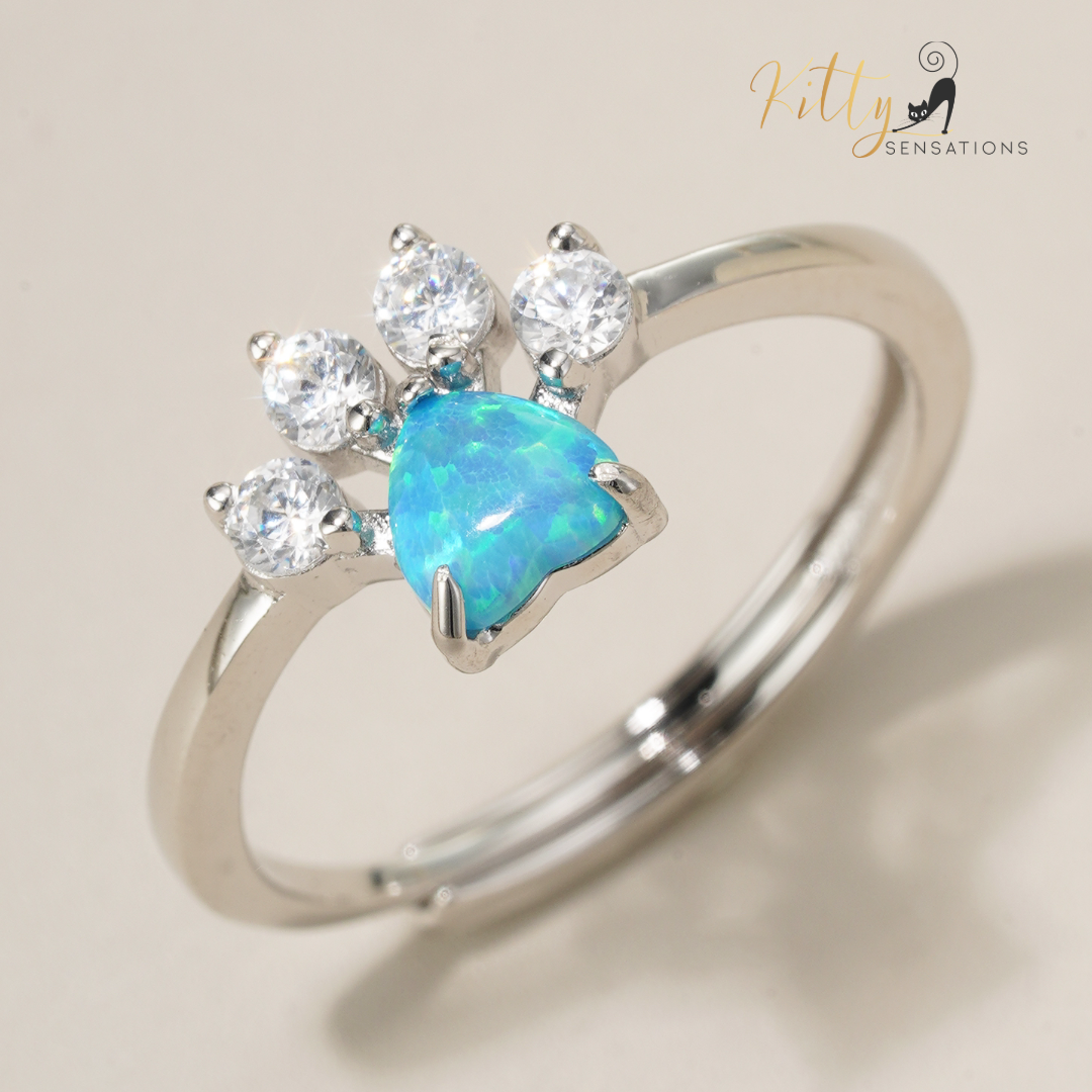 Solid 925 sterling silver cat paw ring with a central heart-shaped blue fire opal stone and four smaller AAA quality clear Cubic Zirconia stones for kitty toes - Rhodium-plated for anti-tarnish and durability.