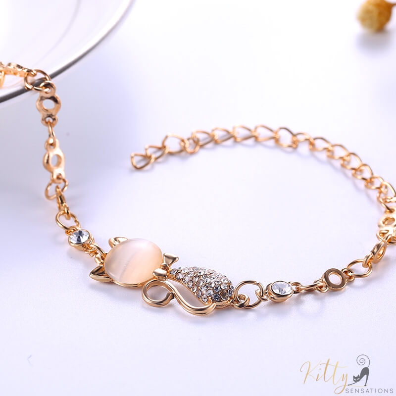 golden cat bracelet with an opal lying on white table 8832864