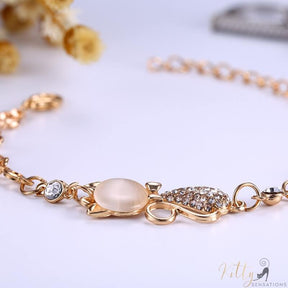 golden cat bracelet with an opal lying on white table 8832864