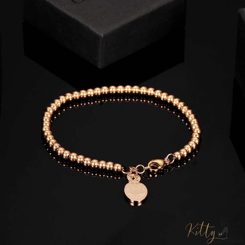 cat charm bracelet plated in rose gold on black surface 4396504-rose-gold-color