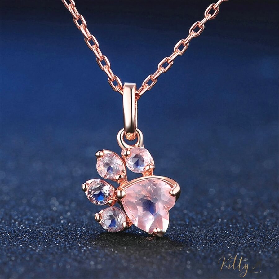 cat paw necklace in rose gold on blue surface 13405465-pink