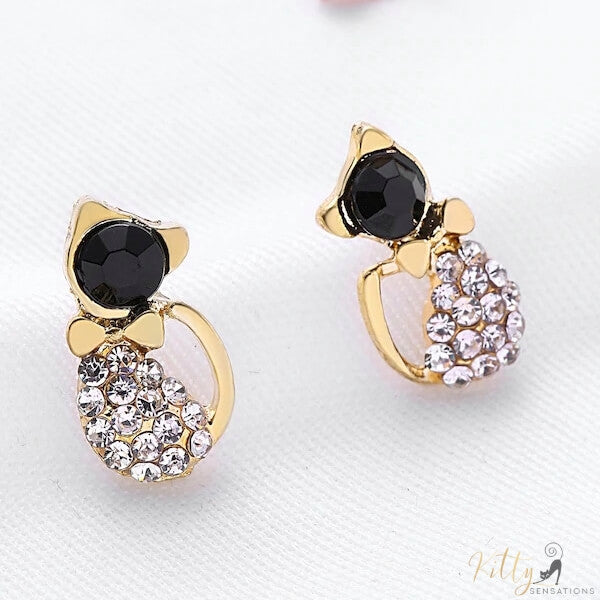 golden cat stud earrings standing on white fabric 4984550-black-cat