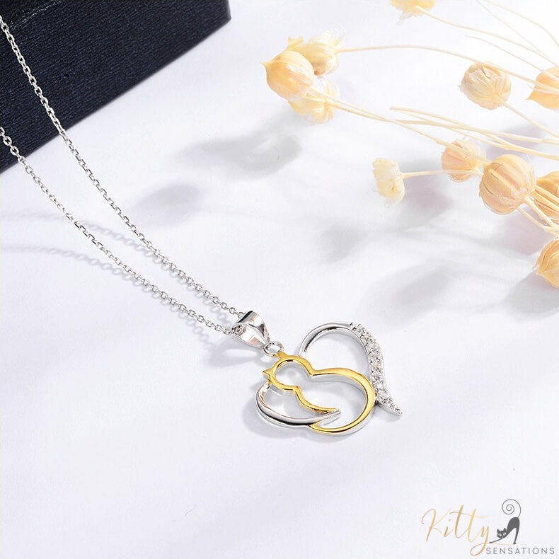 heart cat necklace in silver and gold on white table 4131000